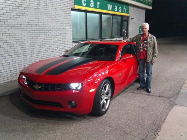 Gary standing beside his red Camaro